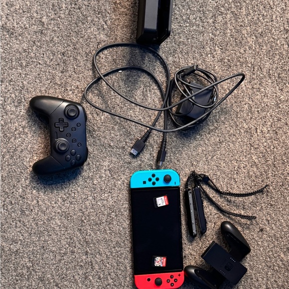 Nintendo switch oled with two games mariocart and supersmashbros and controller.